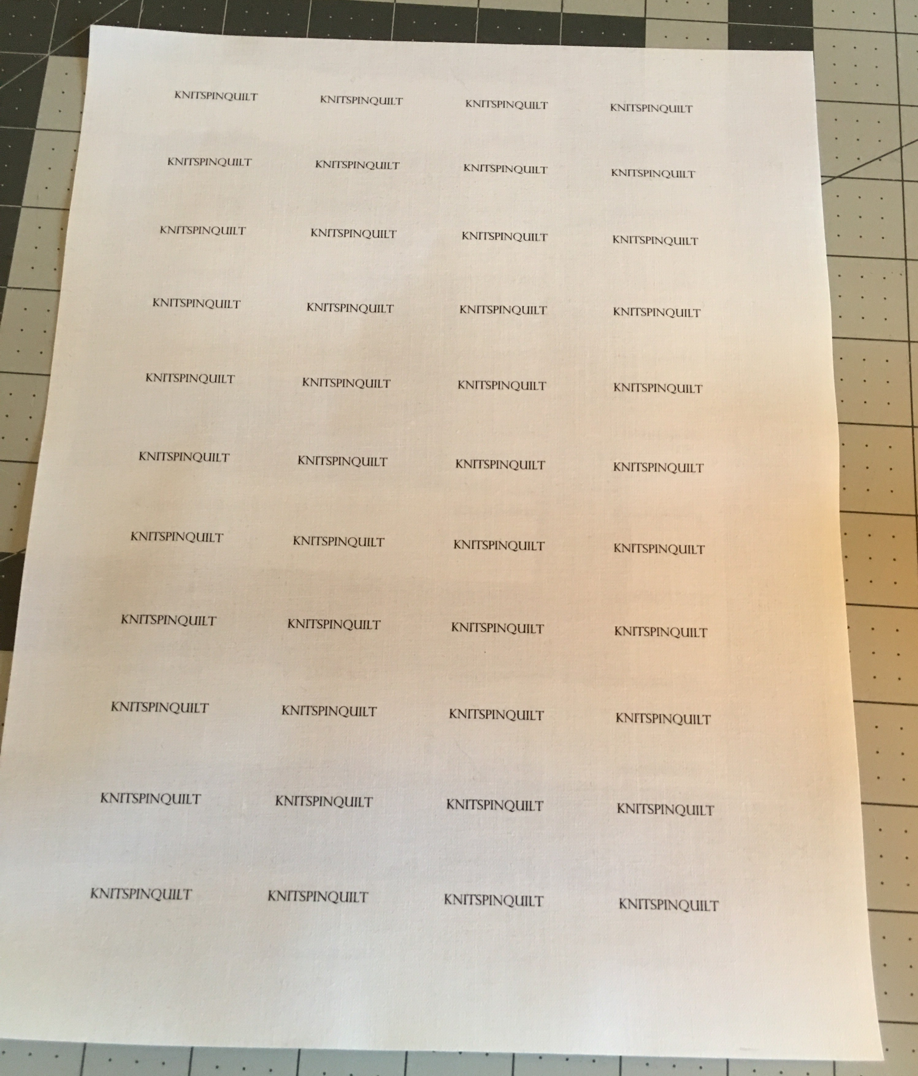 Sheet of printable fabric with KnitSpinQuilt printed repeatedly