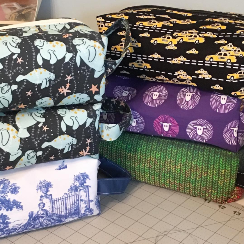Photograph of stacked box bags in a variety of fabrics