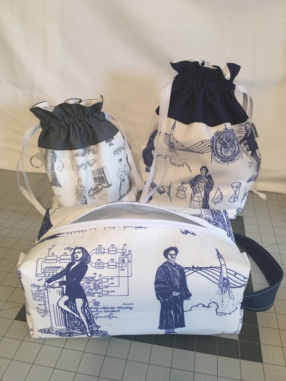 Two drawstring bags and a box bag on a quilting cutting mat