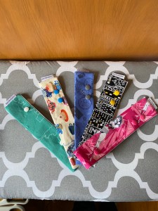 Five rectangular cloth DPN cases arranged in a fan against an ironing board